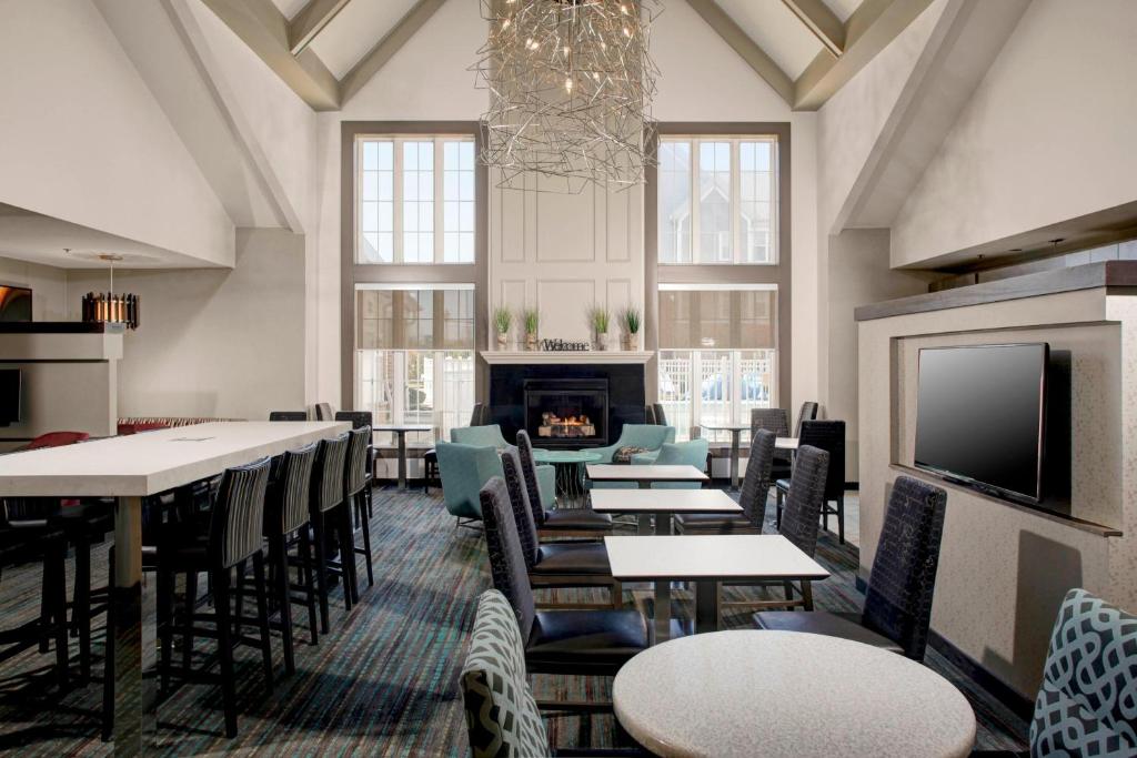 a dining room with tables and chairs and a fireplace at Residence Inn by Marriott Cleveland Mentor in Mentor