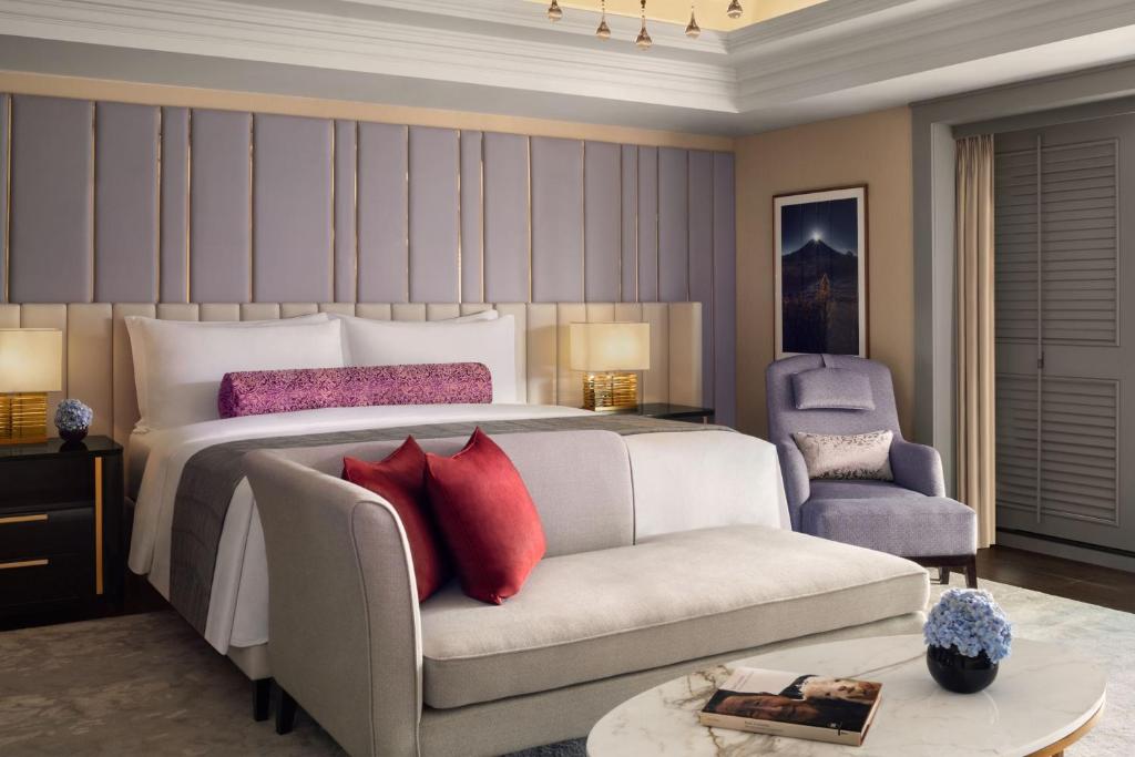 a bedroom with a bed and a couch and a chair at The St. Regis Jakarta in Jakarta