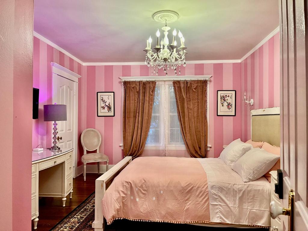 a pink bedroom with a bed and a chandelier at Hollywood Home in Los Angeles
