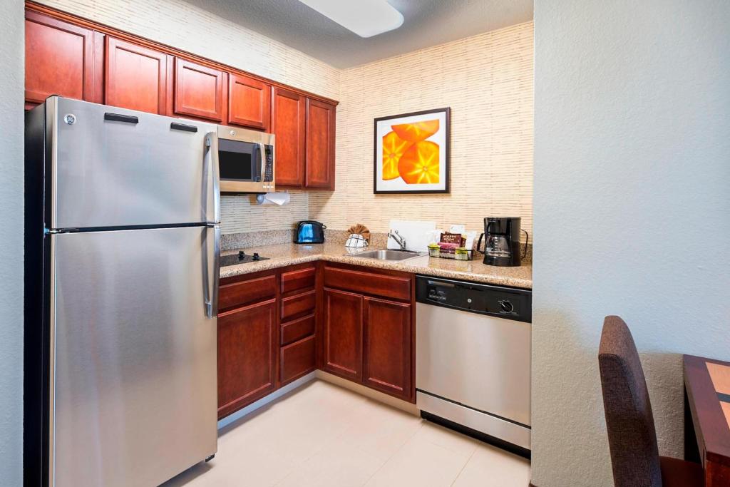 una cocina con electrodomésticos de acero inoxidable y armarios de madera en Residence Inn by Marriott Lakeland, en Lakeland