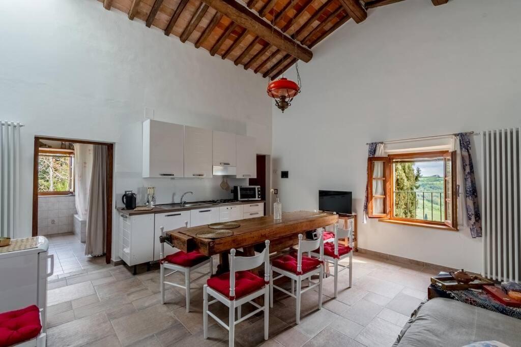 a kitchen with a table and chairs in a room at Appartamento con vista panoramica in Chianti in San Donnino