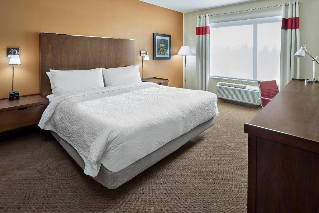 Four Points by Sheraton Edmonton West في إيدمونتون: غرفة فندقية بسرير كبير ونافذة