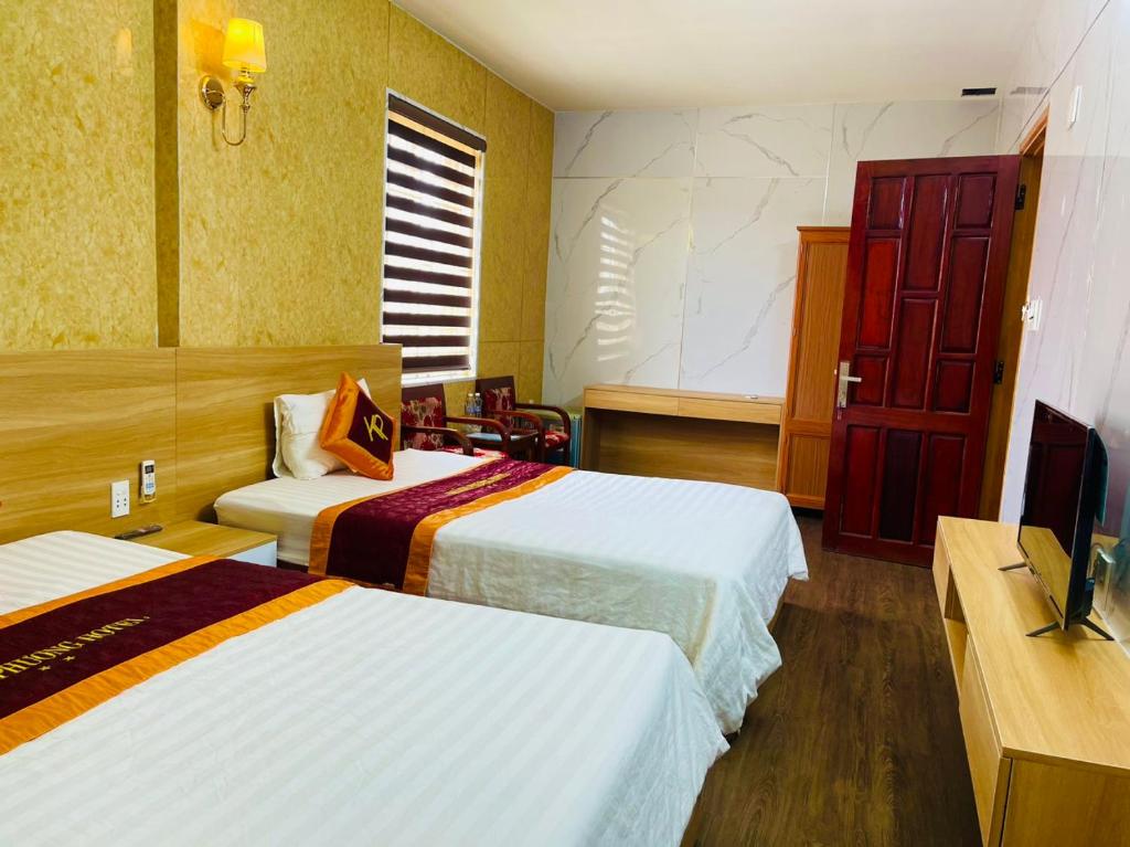 Quảng Trị的住宿－Khách sạn Khánh Phương，酒店客房设有两张床和一台平面电视。