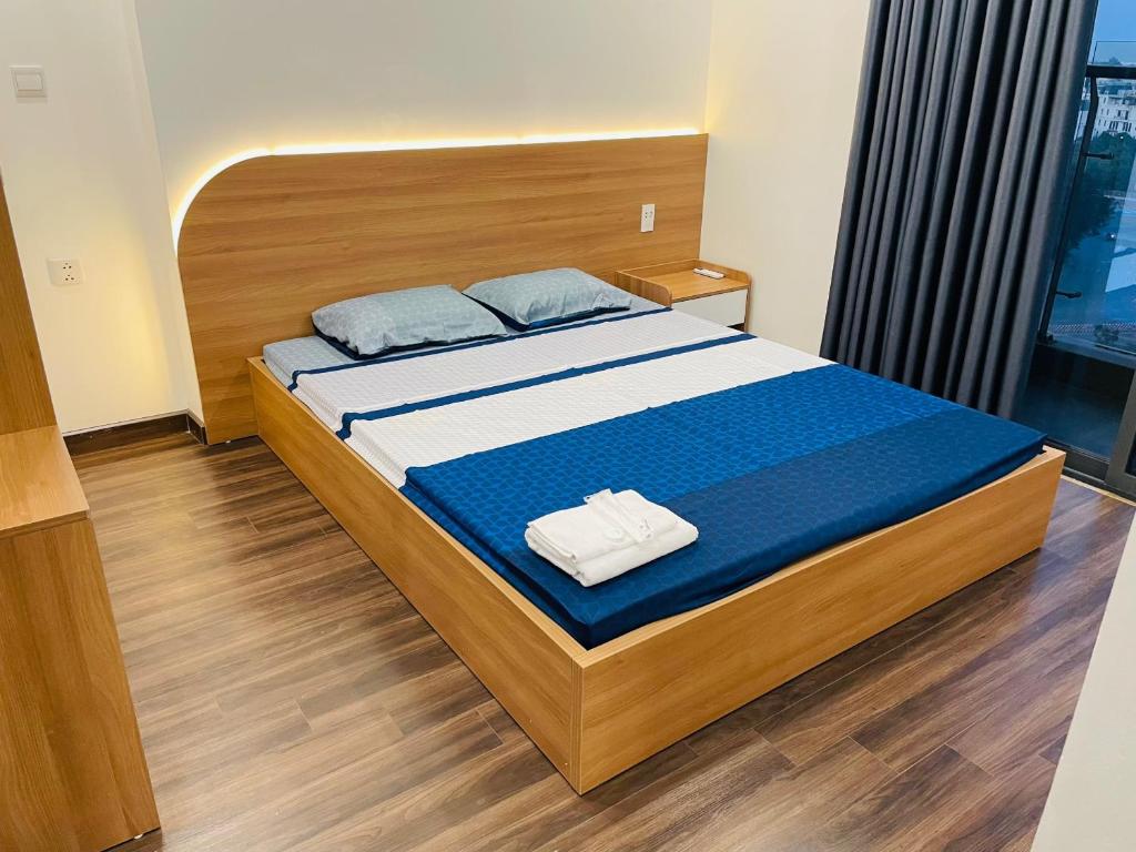 um quarto com uma cama com uma cabeceira de madeira em Căn hộ -Chung cư cao cấp Hoàng Huy Grand Tower em An Lạc