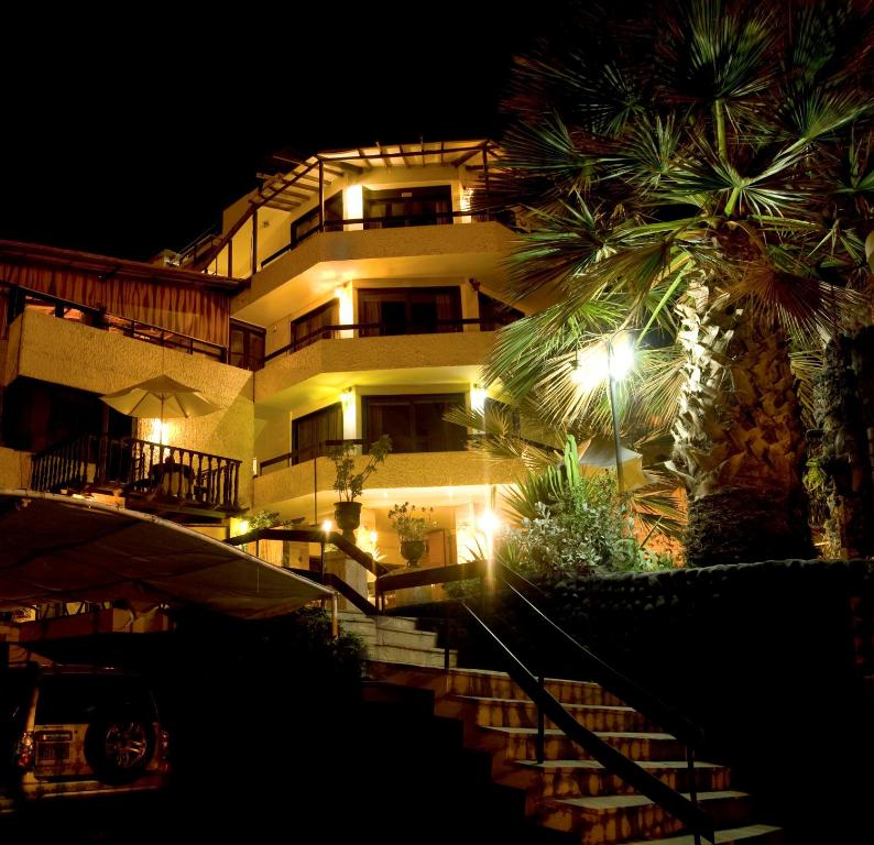 un bâtiment avec des escaliers et un palmier la nuit dans l'établissement Hotel Andenes, à Arequipa