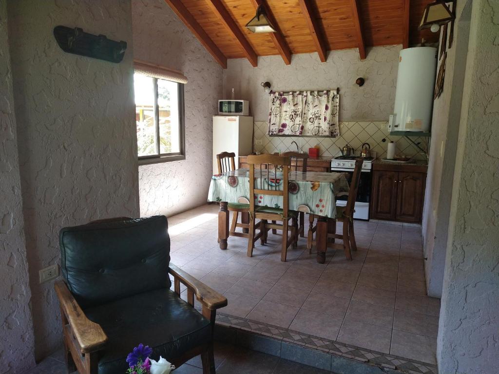 cocina y comedor con mesa y sillas en CABAÑAS VILLA CAMPESTRE en Potrerillos