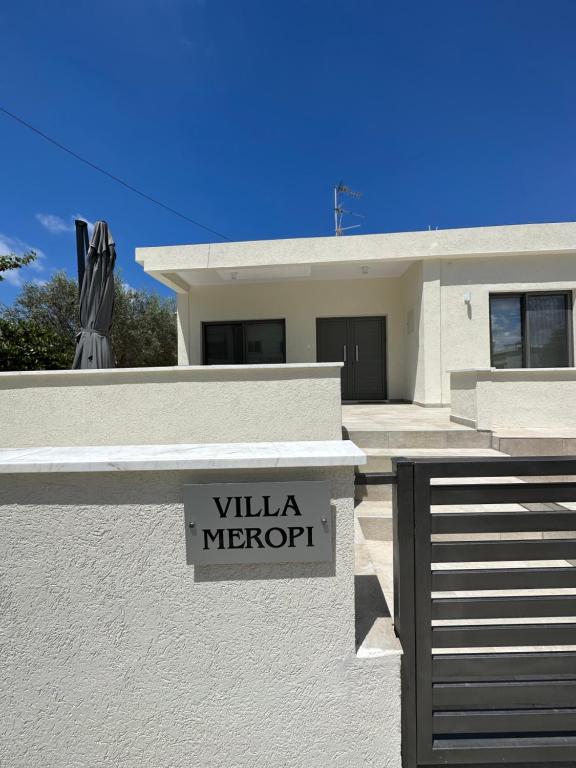 una casa bianca con un cartello che legge "Villa Microport" di Villa Meropi a Paphos