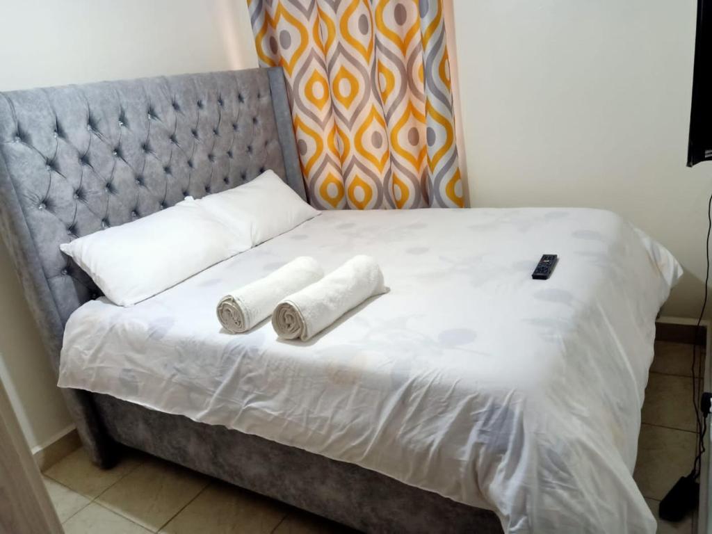 a bed with two rolled up towels on it at B’s homely in Ruiru