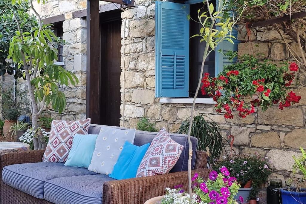 um sofá de vime com almofadas sentadas num pátio em Kalimera A Lovely 1-bedroom rental with ensuite and parking em Limassol