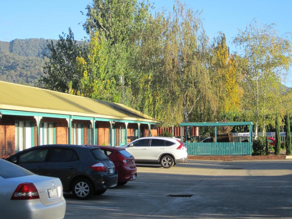 a parking lot with cars parked in front of a building at Snowgum Motel in Mount Beauty
