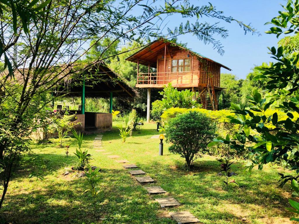 ein Holzhaus mit einem Weg dorthin in der Unterkunft Sungreen Cottage Sigiriya in Sigiriya