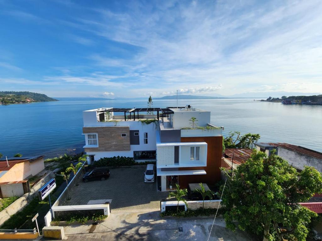 an aerial view of a house next to the water at PURNAMA BALIGE HOTEL in Balige