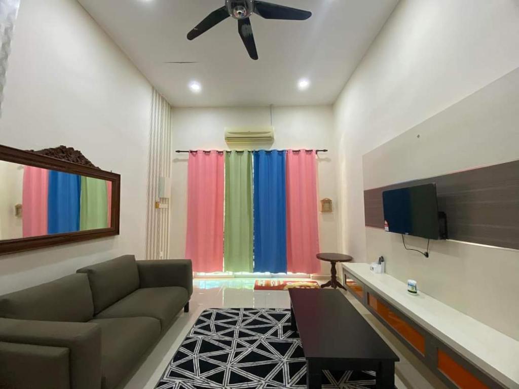 a living room with a couch and a colorful window at Nice and cozy house in Muar in Muar
