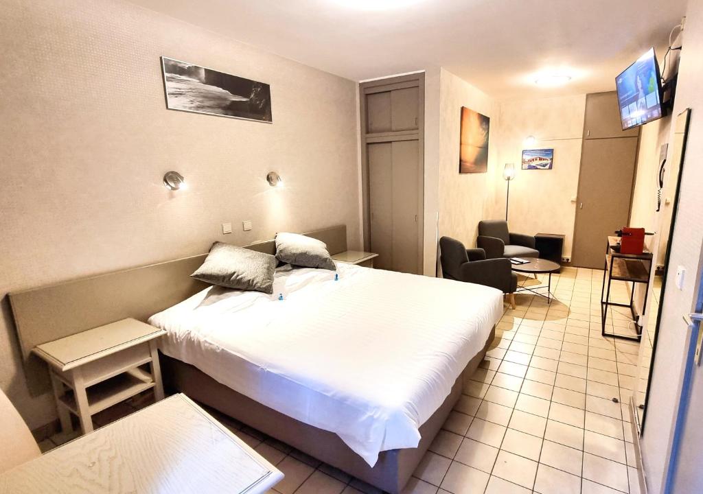 ブレーデネにあるHotel De Golfのベッドと椅子が備わる小さなホテルルームです。