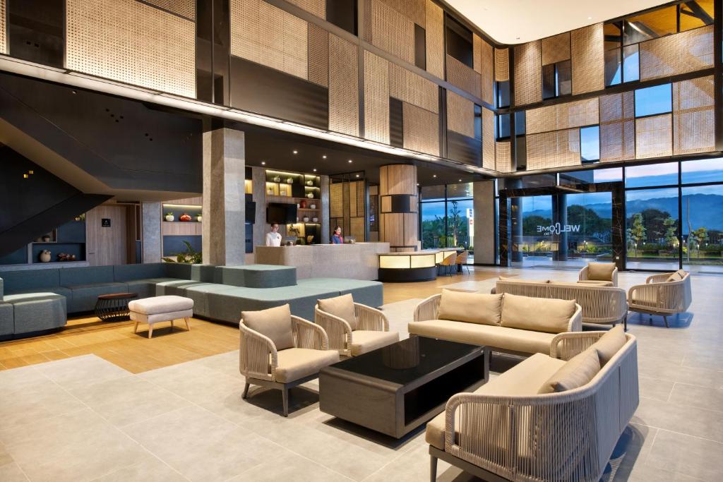 a lobby with couches and chairs in a building at ibis Yogyakarta International Airport Kulon Progo in Yogyakarta