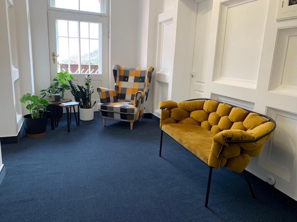 a living room with a yellow couch and chairs at Willa Śmieszek in Sosnówka