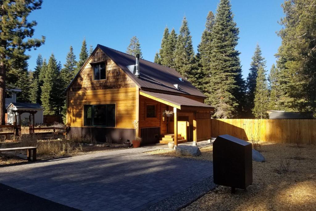 a wooden cabin with a fence and trees at Pine Lantern Retreat in South Lake Tahoe