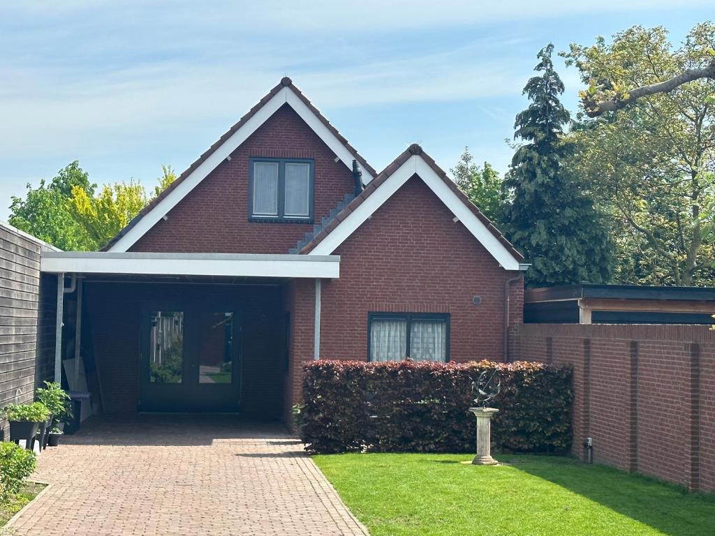 a red brick house with a garage at Bed&Breakfast de Hooimoat in Losser