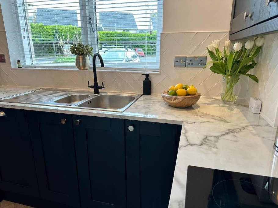 a kitchen with a sink and a bowl of fruit at Machynys Peninsula Home-Beach/Golf/Cycle- Llanelli in Llanelli