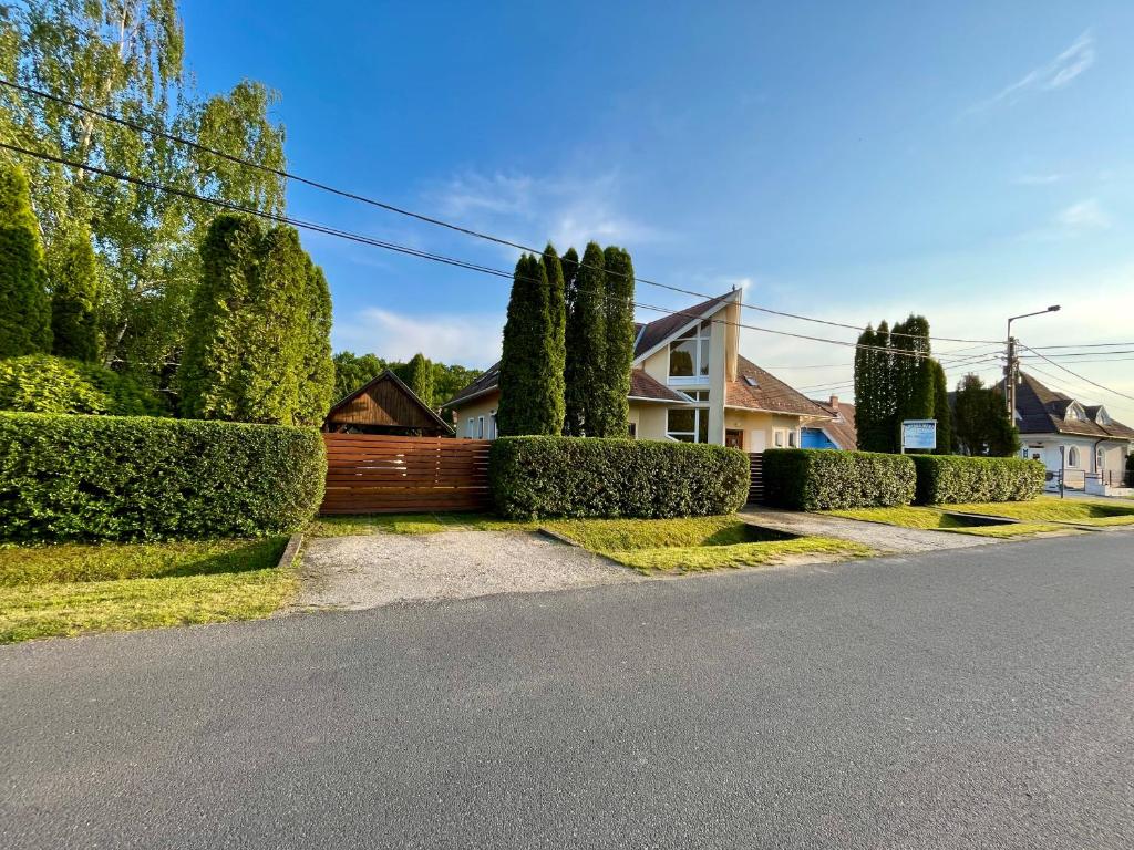 una casa con una valla y árboles en una calle en Mol-Ker-Vill Apartment, en Lenti