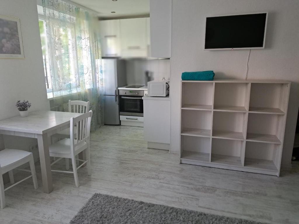 a kitchen with a table and a tv on the wall at Comfort in Daugavpils