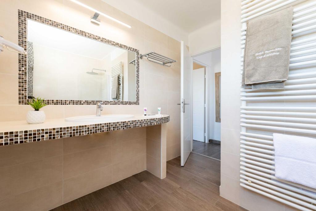 a bathroom with a sink and a mirror at Hôtel Beau Site - Cap d'Antibes in Antibes