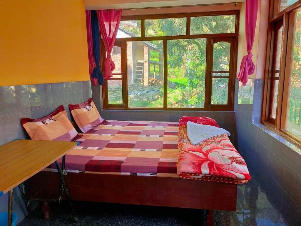 a small bed in a room with a window at The Kashi Baba Homestay in Dharamshala