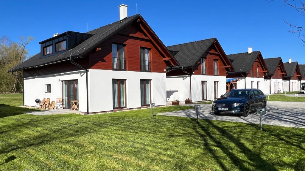 een huis met een auto ervoor geparkeerd bij Apartmány Jura in Nová Pec