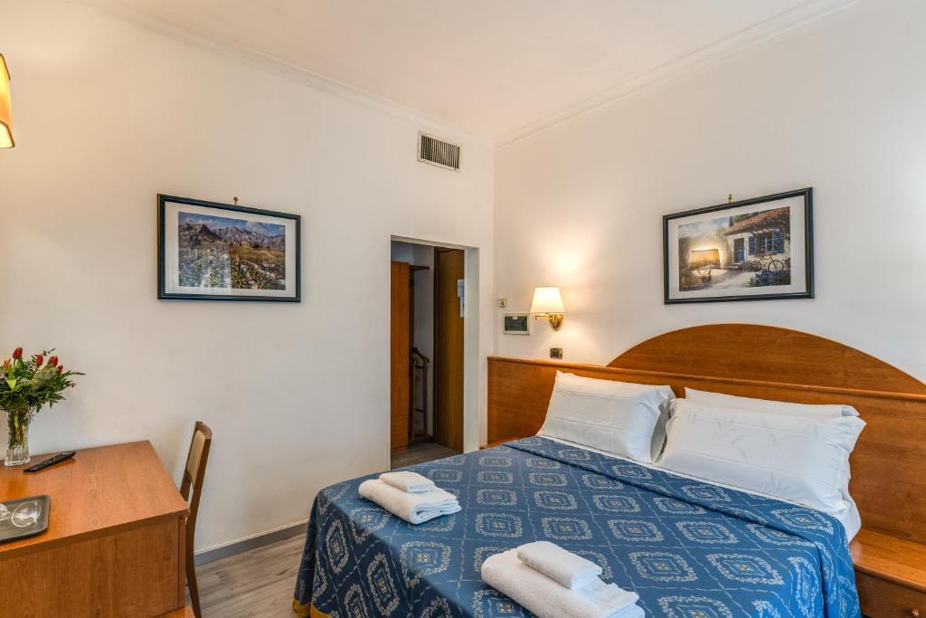 una camera d'albergo con letto e scrivania di Baltik Guesthouse a Roma