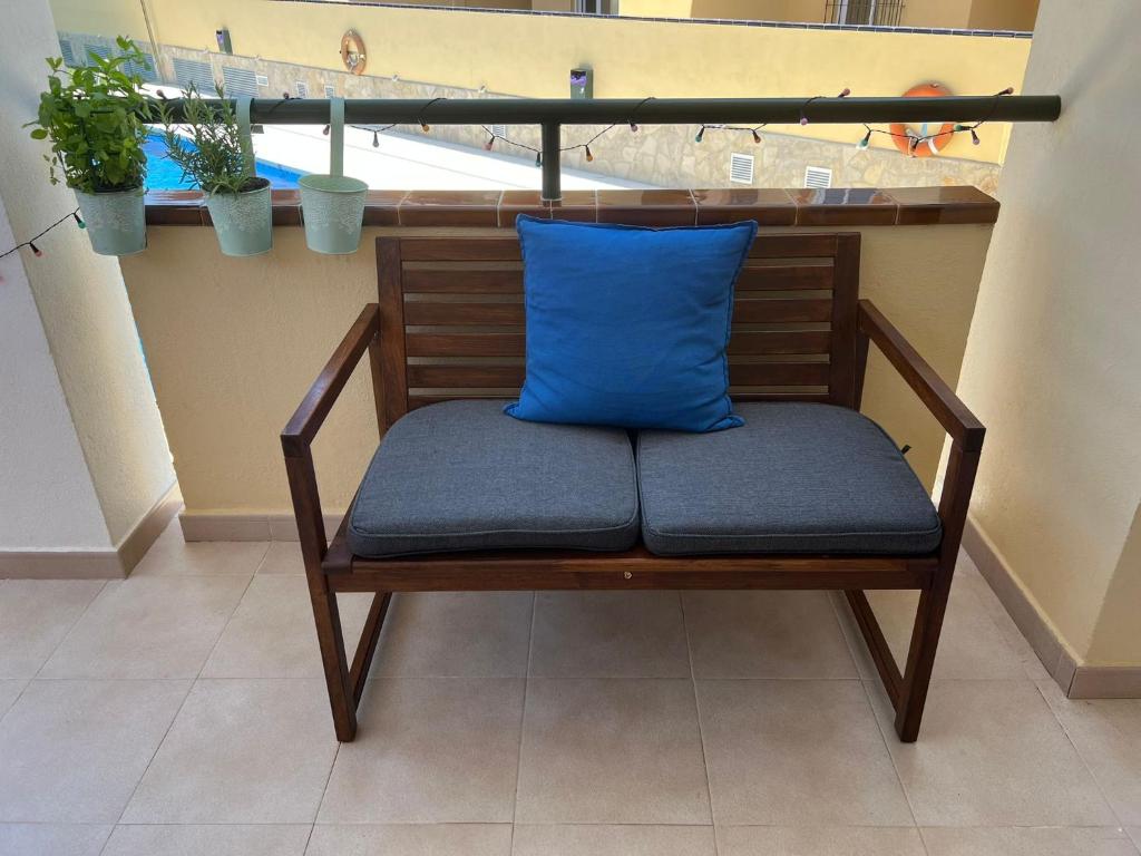 eine Bank mit einem blauen Kissen auf einem Balkon in der Unterkunft Malaga Mijas Costa Pool Nuevo Piso in Mijas Costa