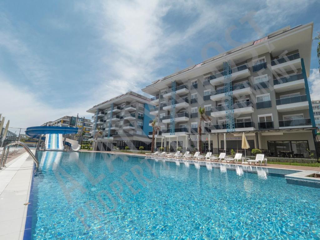 una gran piscina frente a un edificio en Calypso Residence Luxurious Beachside Apartment in Alanya D6, en Alanya