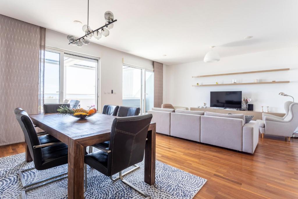 a living room with a table and a couch at Apartments Blue Maris Žnjan in Split
