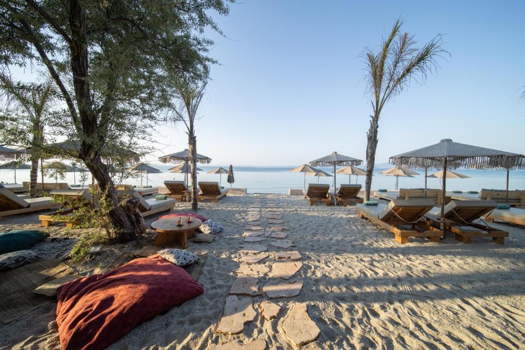 佩科霍里的住宿－MAKO Sea & Suites，海滩上设有椅子和遮阳伞,还有大海