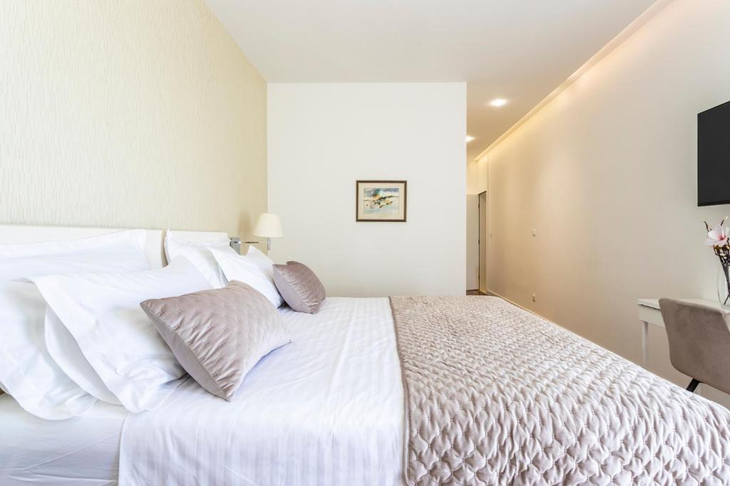 a bedroom with a white bed and a television at Apartments Blue Maris Žnjan in Split
