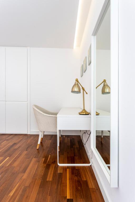 a white desk with a lamp and a chair in a room at Apartments Blue Maris Žnjan in Split