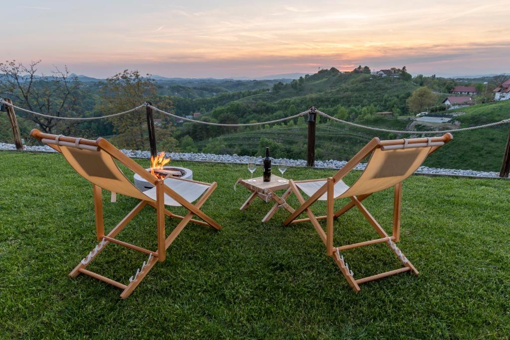 two chairs and a table on the grass at Hill Cottage Haloze in Gruškovec