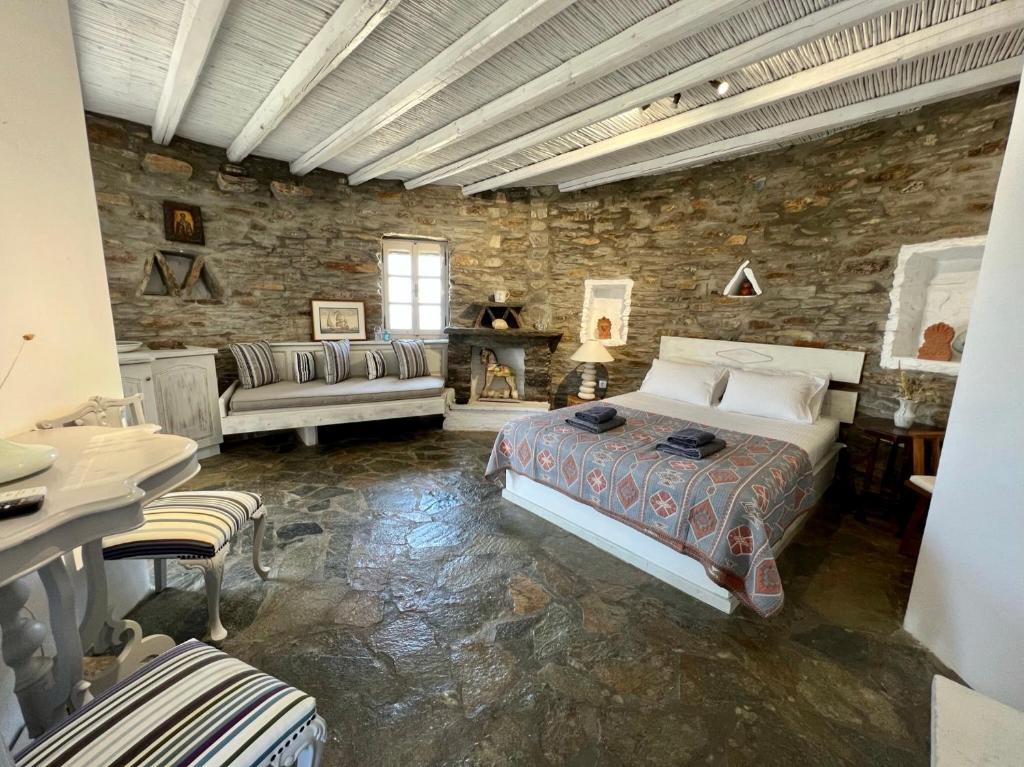 1 dormitorio con cama y pared de piedra en The Stone Windmill, en Koundouros