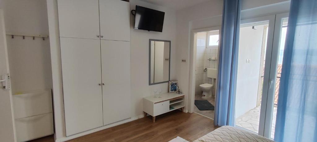 bagno bianco con lavandino e specchio di Bicanic Apartments and Rooms a Crikvenica