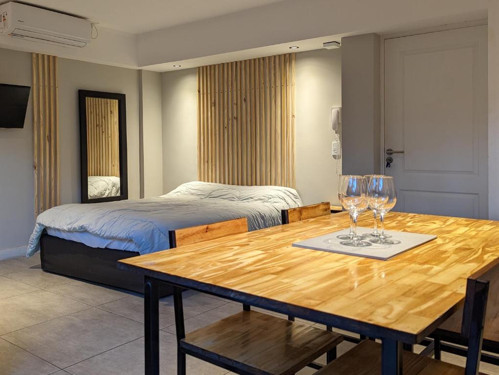 una habitación con una mesa con copas de vino. en Hedonism apartments en Mar del Plata