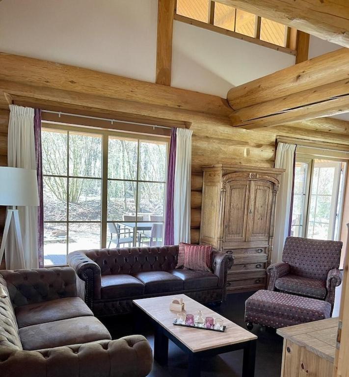 Een zitgedeelte bij Unieke houten villa met SAUNA in Twente - 5p