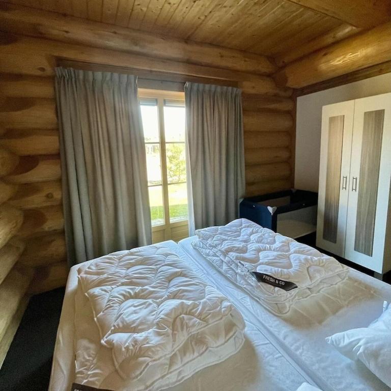 Een bed of bedden in een kamer bij Unieke houten villa met SAUNA in Twente - 5p