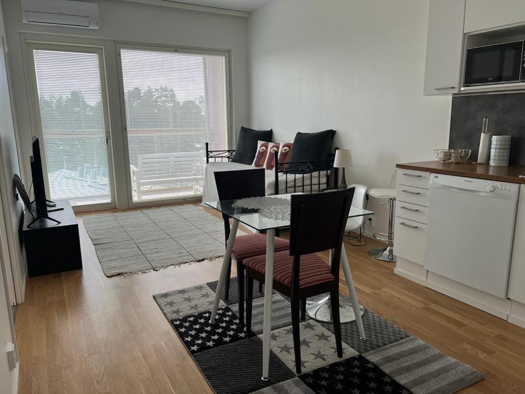 een keuken met een tafel en stoelen in een kamer bij Modern apartment nearby Airport 2 in Vantaa