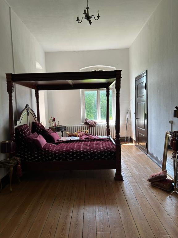 1 dormitorio con cama de madera y dosel en Ferienwohnung Adelheid 