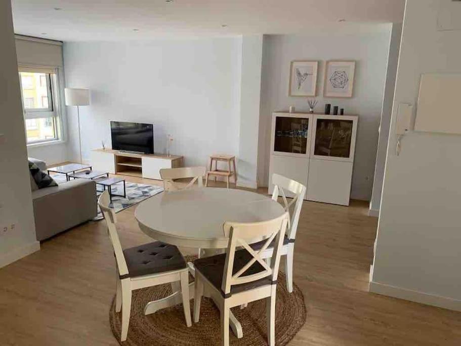 een woonkamer met een tafel en stoelen bij Piso recién reformado, cómodo y muy luminoso. in Ferrol