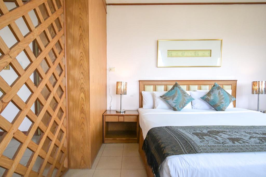 Rattana Park Hotel في بيتسانولوك: غرفه فندقيه بسرير ودرج