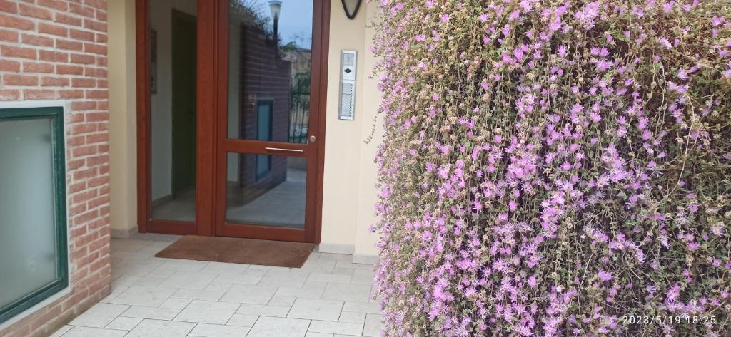 a wall covered in purple flowers next to a door at Seven Sardinia in Cagliari