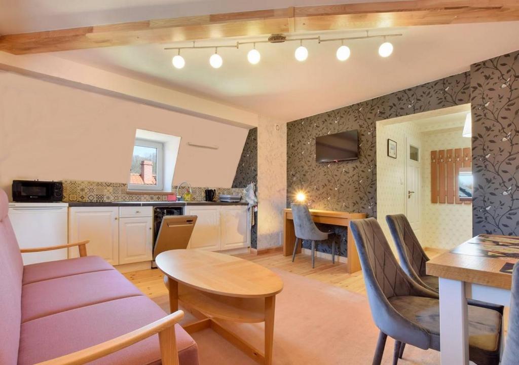 a kitchen and living room with a table and chairs at Apartamenty Willa & sauny in Kudowa-Zdrój