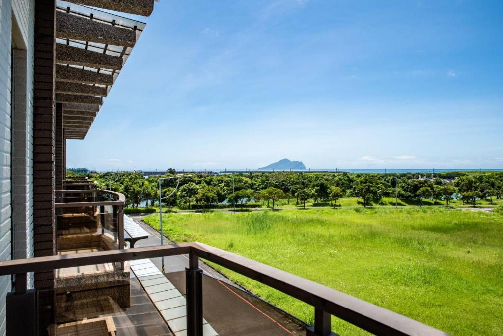 uma varanda com vista para um campo verde em Wind Breathing B&B em Toucheng