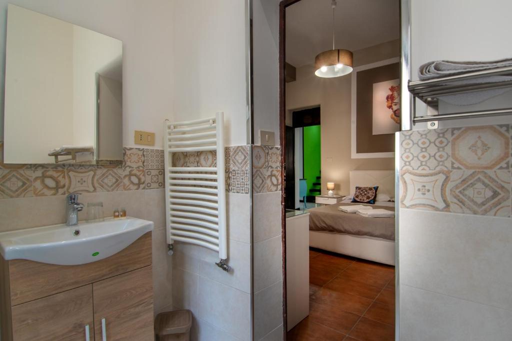 1 dormitorio y un baño pequeño con lavabo. en La Casa del Moro, en Palermo