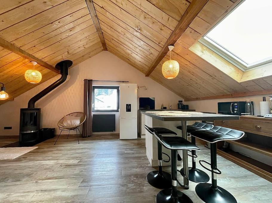 een keuken met een tafel en stoelen in een kamer bij Au Cocon du Haut Pergé in Gérardmer